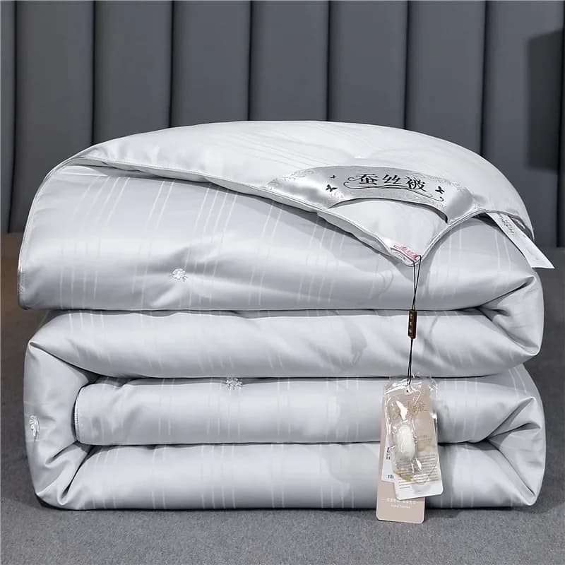 A folded grey silk-filled duvet with a silk cocoon label