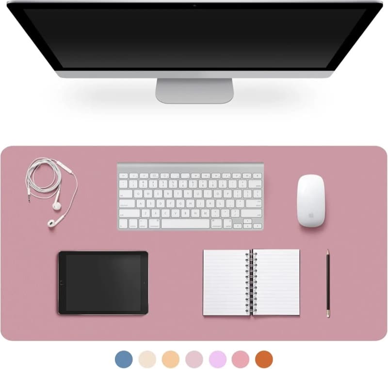 A pale mauve desk mat on a desk with a keyboard, mouse, tablet and notebook